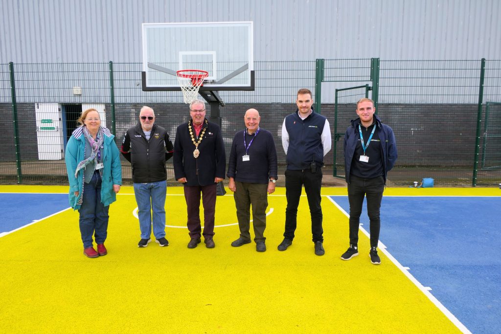 Photo on the new MUGA at Caldicot Leisure centre. From left to right, Cllr Jackie Strong, Cllr I R Shillabeer, Caldicot Town Council, Chair of Monmouthshire County Council Cllr Meirion Howells, Cabinet Member for Education Cllr Martyn Groucutt, Joe Killingley, Caldicot Leisure Centre Manager and Jack Harris, Community and Sport Development Officer.
